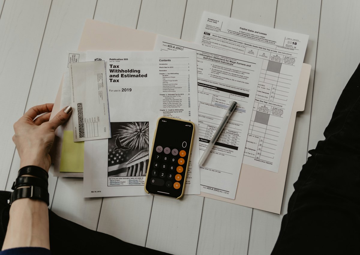 Pessoa analisando documentos fiscais com calculadora